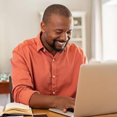 Man smiling at desk using laptop