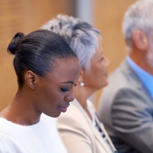 Meeting room with staff seated and listening.