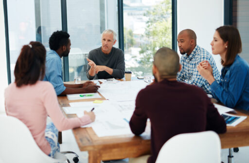 A group of people sitting at a table having a discussion.